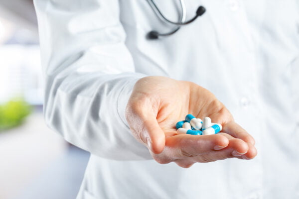 Freepik Imagem Dr segurando cápsulas de medicamento