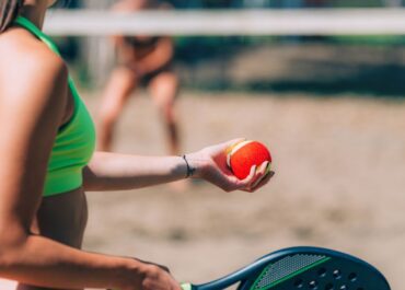 Imagem de grupo de pessoas jogando beach tennis.